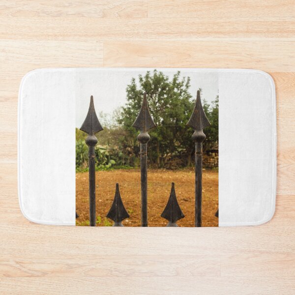Item preview, Rusty Iron Fence Spikes In Front Of A Garden Yard With Greenery Background designed and sold by Nmallia.