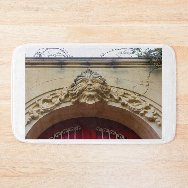 Item preview, Ornate Stone Archway With Carved Face Sculpture And Vine Details Above Red Door designed and sold by Nmallia.