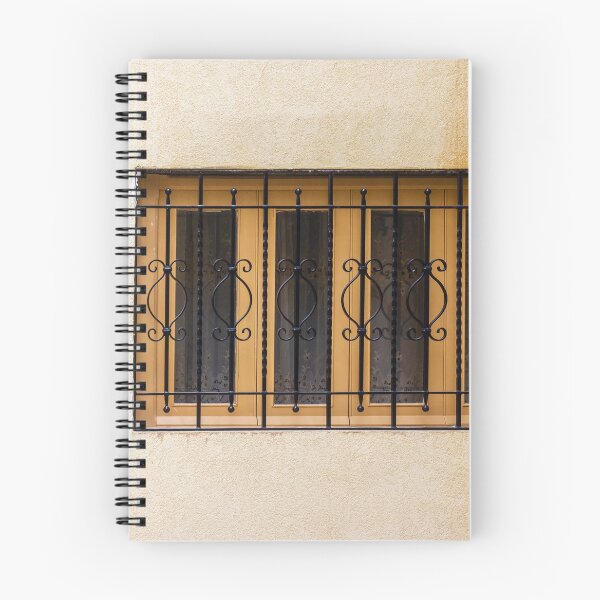 Item preview, Yellow Wall With Decorative Iron Window Bars Guarding A Beige Facade On A Quiet Street Scene designed and sold by Nmallia.