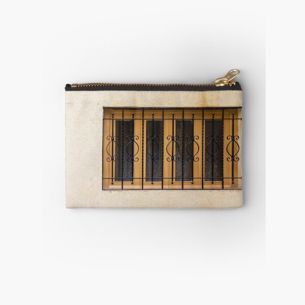 Item preview, Yellow Wall With Decorative Iron Window Bars Guarding A Beige Facade On A Quiet Street Scene designed and sold by Nmallia.