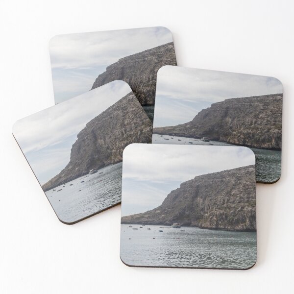 Item preview, Boats Anchored in a Quiet Rocky Bay Beneath a Dramatic Cliffside Under Overcast Sky designed and sold by Nmallia.