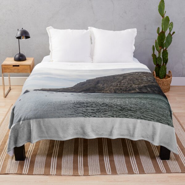 Item preview, Boats Anchored in a Quiet Rocky Bay Beneath a Dramatic Cliffside Under Overcast Sky designed and sold by Nmallia.