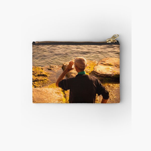 Item preview, Man Sitting On Rocky Coastline Drinking Water At Sunset designed and sold by Francisera.