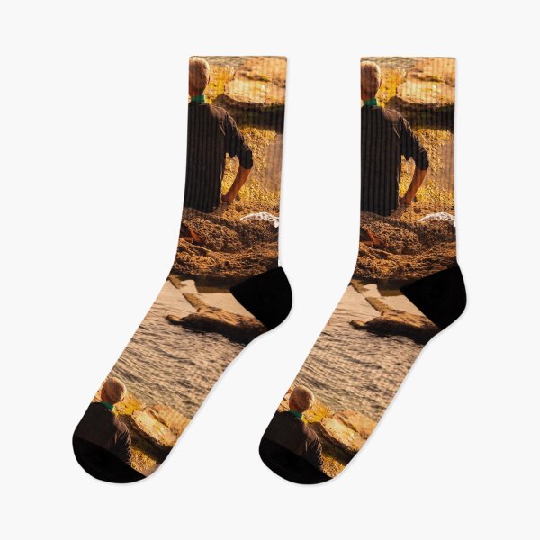 Item preview, Man Sitting On Rocky Coastline Drinking Water At Sunset designed and sold by Francisera.
