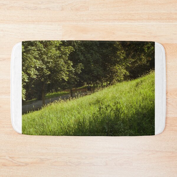 Item preview, Sunlit Grassy Slope Beside Tree-Lined Pathway designed and sold by Squikale.