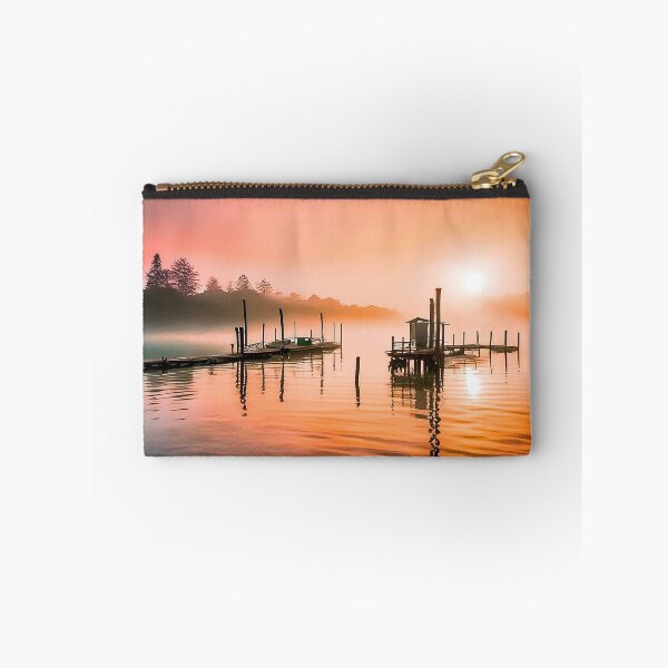 Item preview, Tranquil sunrise over a wooden pier and hut on calm water designed and sold by homydesign.