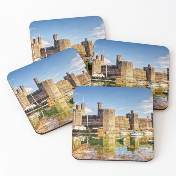 Item preview, Caernarfon Castle reflected in the tranquil waters of its harbour, with a historic vessel moored beneath the imposing medieval fortress.  designed and sold by Kevin Hellon.