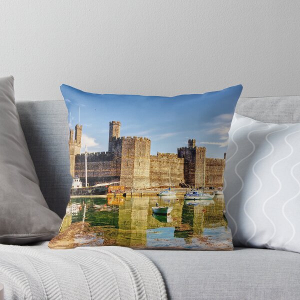 Item preview, Caernarfon Castle reflected in the tranquil waters of its harbour, with a historic vessel moored beneath the imposing medieval fortress.  designed and sold by Kevin Hellon.