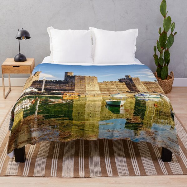 Item preview, Caernarfon Castle reflected in the tranquil waters of its harbour, with a historic vessel moored beneath the imposing medieval fortress. designed and sold by Kevin Hellon.