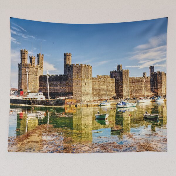 Item preview, Caernarfon Castle reflected in the tranquil waters of its harbour, with a historic vessel moored beneath the imposing medieval fortress.  designed and sold by Kevin Hellon.
