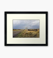 old pilgrim's trail marker beneath stormy clouds Framed Print