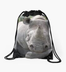 Rhino looking relaxed with head resting on forearm. Drawstring Bag