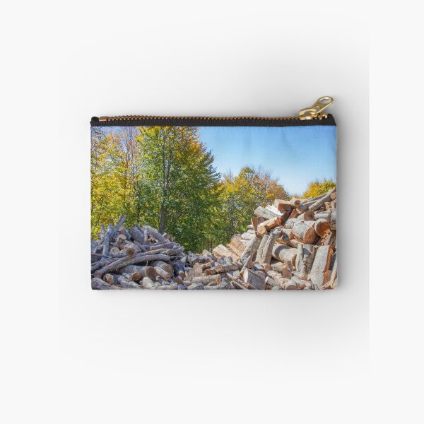 Item preview, Sawn tree trunks of different sizes laying in pile against a background of blue sky and trees with autumn foliage. Greece designed and sold by EG Creativity Art.