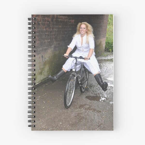 Artikelvorschau, Young blonde woman riding a bicycle, wearing wellington boots. entworfen und verkauft von imageunlimited.
