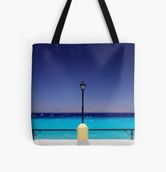 Turquoise sea with dark blue sky and a pylon in Greece All Over Print Tote Bag