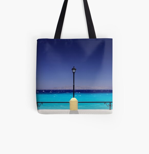 Turquoise sea with dark blue sky and a pylon in Greece All Over Print Tote Bag