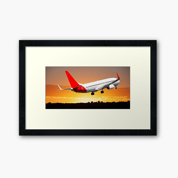 Jet airliner flying in a colourful orange stratocumulus cloudy sky. Framed Art Print