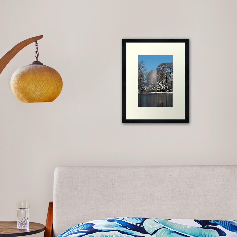 Rainbow fountain in snowy park Framed Art Print