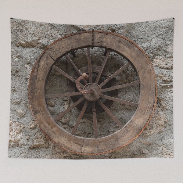 Item preview, Wooden wheel hanging on a stone wall designed and sold by brambillasimone.