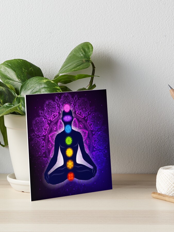 Meditating human in lotus pose. Yoga - 7 chakras and aura glow. Mandala  background.