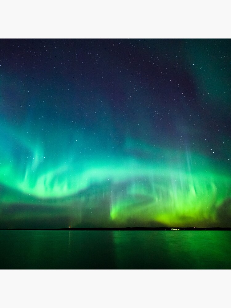 Northern lights glow over lake by Juhku