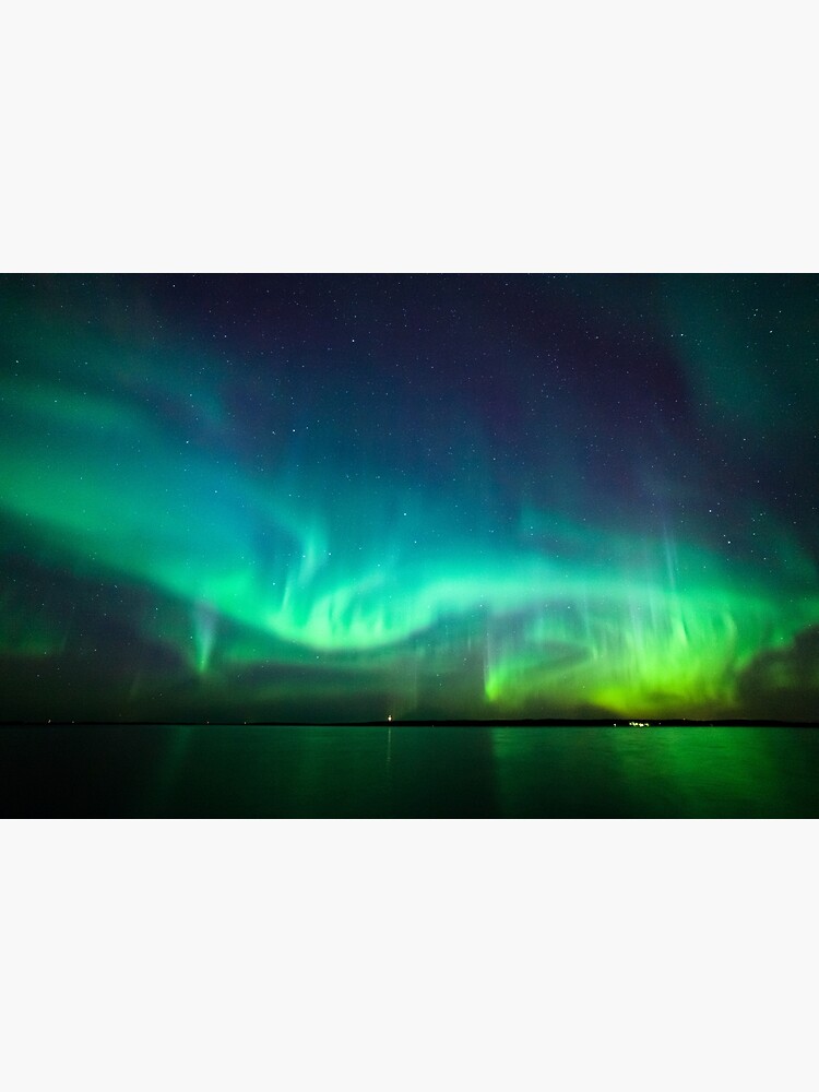 Northern lights glow over lake by Juhku