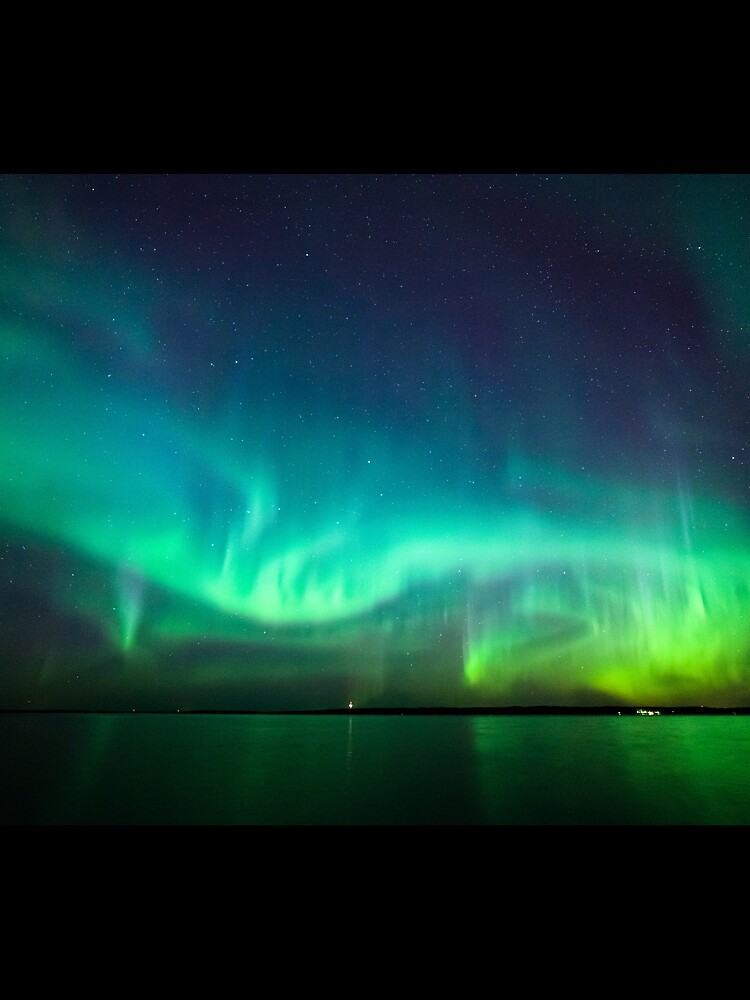 Northern lights glow over lake by Juhku