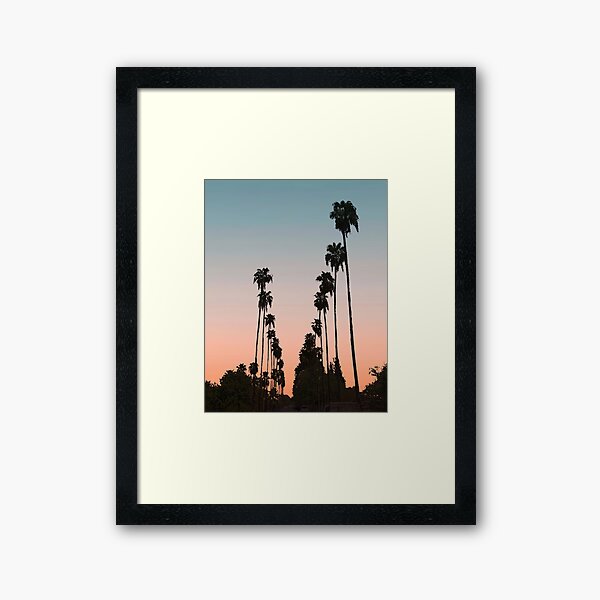 Aperçu de l'œuvre Coucher de soleil en Californie // Image de la silhouette d'un palmier dans la rue avec un ciel orange et bleu créée et vendue par desertxpalm.