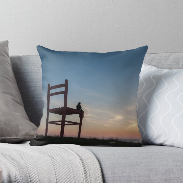 photograph a man on a huge chair at sunset in Îles-de-la-Madeleine Throw Pillow