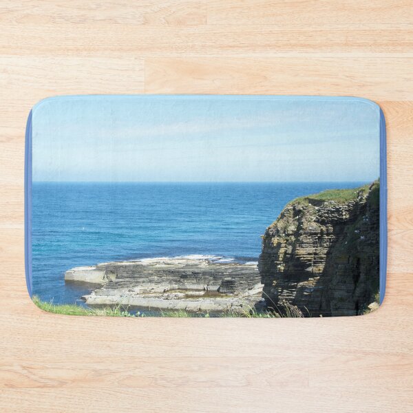 Rocks and raised ledge in sea Bath Mat