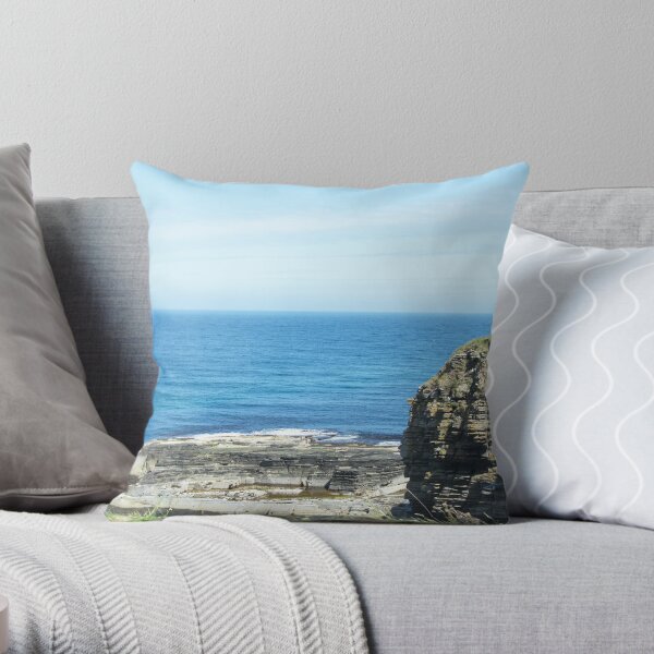Rocks and raised ledge in sea Throw Pillow