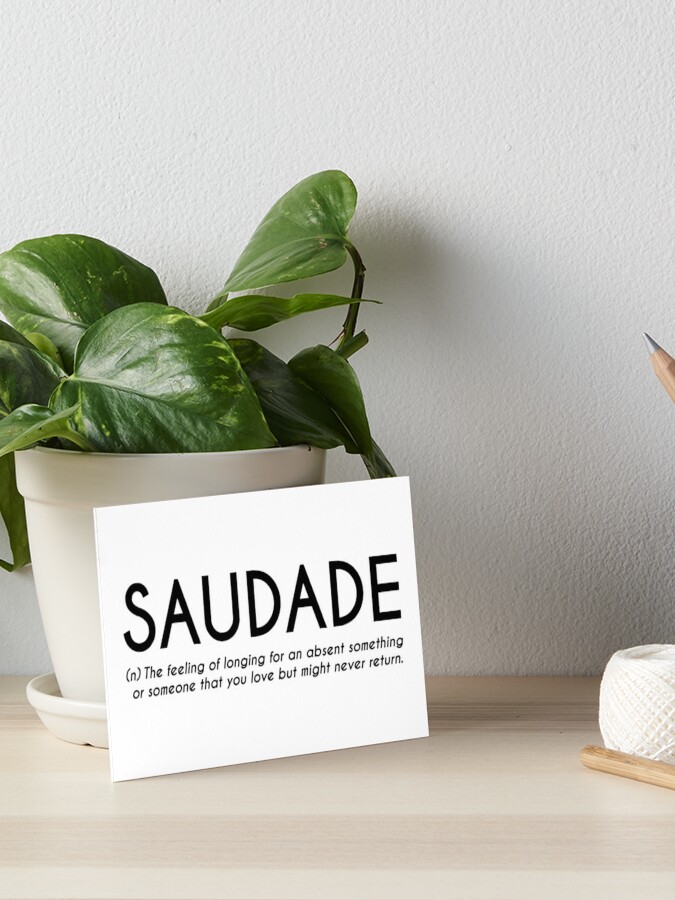 Saudade, Portuguese word meaning nostalgia or longing composed with yellow  colored stone letters over green sand Stock Photo - Alamy
