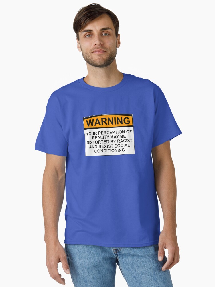 Imagen 1 de 7, Camiseta clásica con la obra ADVERTENCIA: SU PERCEPCIÓN DE LA REALIDAD PUEDE ESTAR DISTORSIONADA POR CONDICIONAMIENTOS SOCIALES RACISTAS Y SEXISTAS, diseñada y vendida por wanungara.