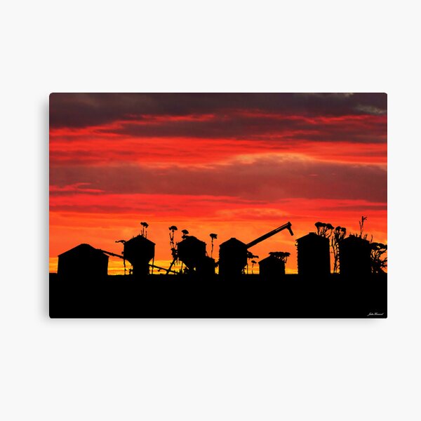 Sunset over wheat silos Canvas Print