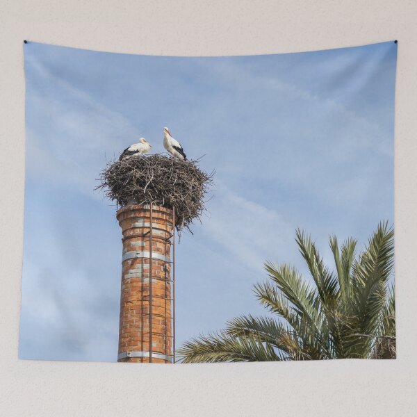 Item preview, Bringing Babies - White Storks Nesting on a Tall Brick Chimney Above the Treetops designed and sold by Georgia Mizuleva.