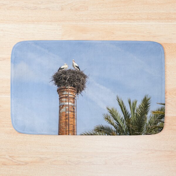 Item preview, Bringing Babies - White Storks Nesting on a Tall Brick Chimney Above the Treetops designed and sold by Georgia Mizuleva.
